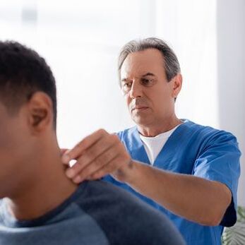 Le médecin procède à un examen diagnostique d'un patient souffrant de douleurs au cou