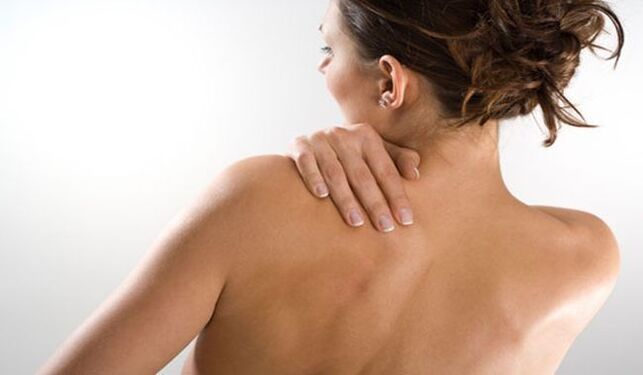 La femme est préoccupée par la douleur sous l'omoplate gauche dans le dos du dos